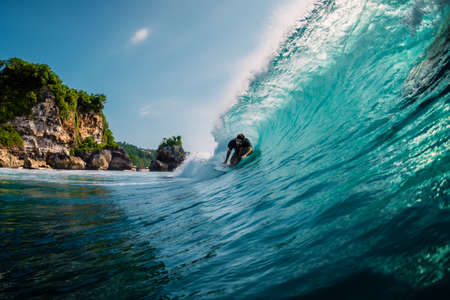 April 17, 2019. Bali, Indonesia. Surfer ride on surfboard at barrel wave. Professional surfing in oceanのeditorial素材