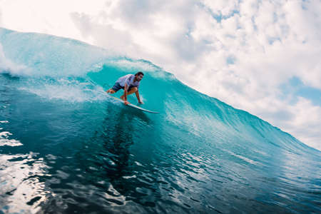 April 17, 2019. Bali, Indonesia. Surfer ride on surfboard at barrel wave. Professional surfing in oceanのeditorial素材