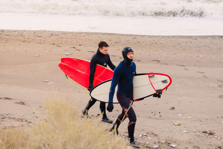 November 22, 2019. Crimea, Russia. Surfer in wetsuit with surfboard at beach.のeditorial素材
