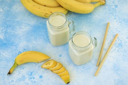 Healthy yogurt or smoothie with banana, vegetarian food, diet and health conceptの写真素材