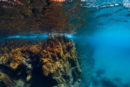 Underwater scene with rocks in blue water in the ocean