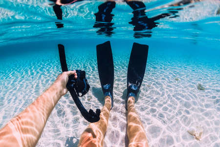 Freediver relax with fins and mask on sand bottom in tropical ocean underwater in Hawaiiの写真素材