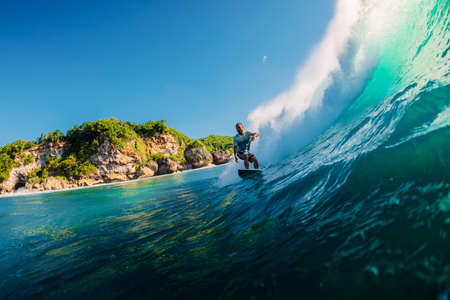 July 12, 2020. Bali, Indonesia. Surfer ride on surfboard at barrel wave. Surfing at Padang Padang