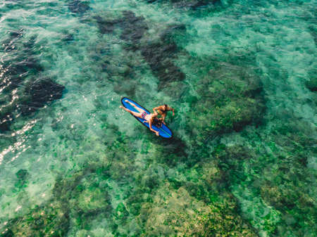 June 06, 2020. Bali, Indonesia. Aerial view of family with child and surfboard in ocean. Surfers family relax in waterのeditorial素材