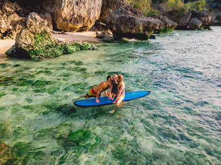 June 06, 2020. Bali, Indonesia. Aerial view of family with child and surfboard in ocean. Surfers family relax in waterのeditorial素材