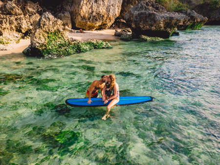 June 06, 2020. Bali, Indonesia. Aerial view of family with child and surfboard in ocean. Surfers family relax in waterのeditorial素材