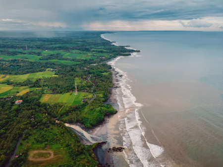 Aerial view of coastline with black sand beach, ocean and waves in Balian, Baliの写真素材