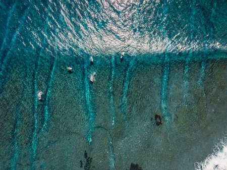 Aerial view of a surfers in blue ocean with waves. Top view