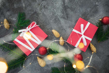 Christmas composition with golden branches, gifts, lights and decoration on dark background. Flat lay, top viewの写真素材