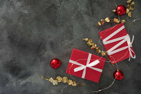 Christmas composition with golden branches, gifts, lights and decoration on dark background. Flat lay, top viewの写真素材