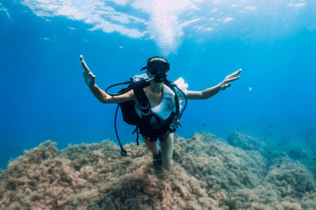 August 20, 2020. Anapa, Russia. Woman scuba diver glides underwater in transparent blue sea. Scuba diving in oceanのeditorial素材