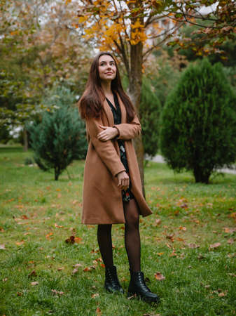 Portrait of young attractive woman in park. Woman in coatの写真素材