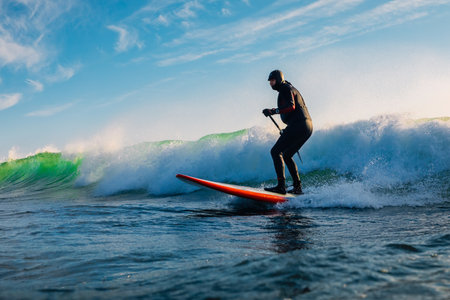 December 8, 2020. Anapa, Russia. Stand Up Paddle surfing on waves. Surfer in wetsuit with paddle ride on sea waveのeditorial素材
