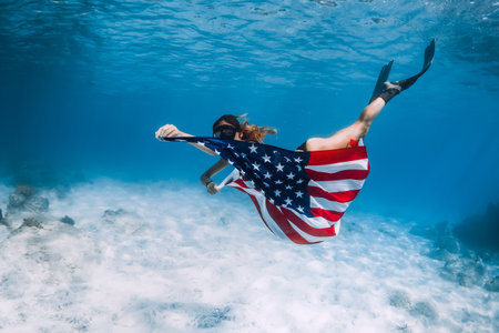 Young woman freediver glides with fins in tropical oceanの写真素材