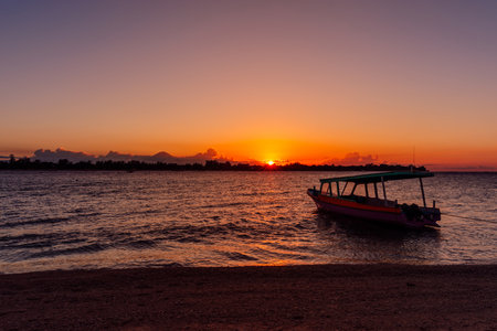 Boat and sunset or sunrise at tropical beach with ocean in Gili islandの写真素材