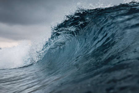 Perfect ocean waves with blue water cloudy dark sky.の写真素材