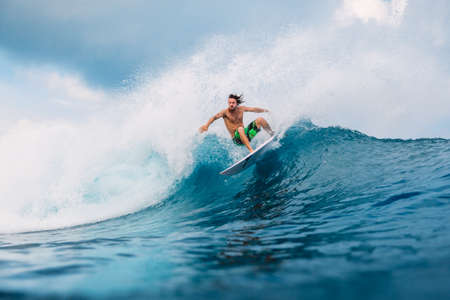 January 21, 2021. Bali, Indonesia. Caucasian young surfer ride at ocean wave on the surfboard.のeditorial素材