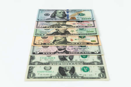 US dollars. Finance background of 5, 10, 20, 50 and 100 dollar bills on whiteの写真素材