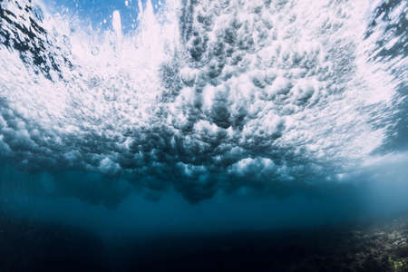 Wave underwater with foam, bubbles and sunlight. Transparent ocean in underwaterの写真素材