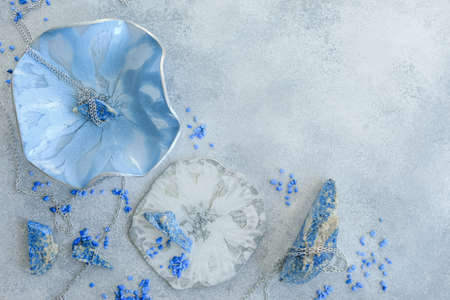 Composition with resin art plate and blue stones on gray background. Epoxy resin art. Flat lay