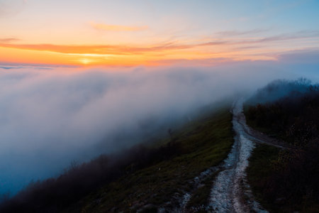 Creeping fog with sunset and mountains. Foggy weather in springの写真素材