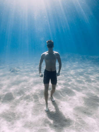 Free diver make ring bubble underwater. Sporty man freediver in summer sea