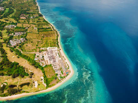 Tropical island with resort, beach and turquoise ocean, aerial view. Gili islands
