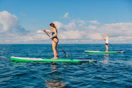 June 13, 2021. Anapa, Russia. Couple on stand up paddle board at quiet sea. People traveling on...