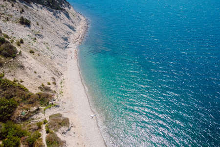 Aerial view of coastline with pine trees and blue transparent sea. Summer day on Black sea