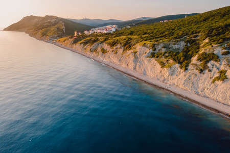 Aerial view of summer coastline with grass and blue sea. Coastline with sunset colorsの素材 [FY310172209725]