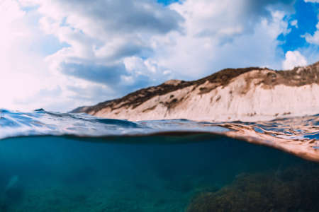 Split shot with coastline and underwater scene with sun rays and transparent sea water.の写真素材