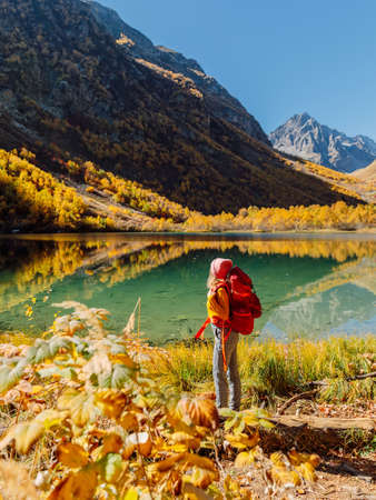 Portrait of happy woman at crystal lake in the autumnal mountains.の写真素材