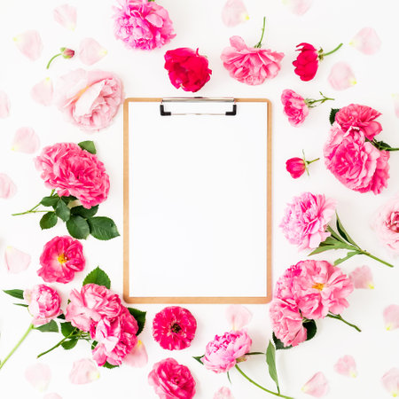 Blogger of freelancer composition with clipboard and pink roses on white background. Flat lay, top view.の写真素材