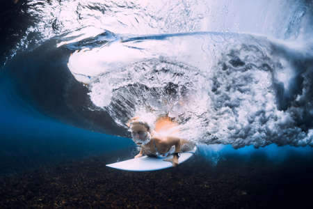 Woman swim under ocean wave. Duck dive under crashing waves