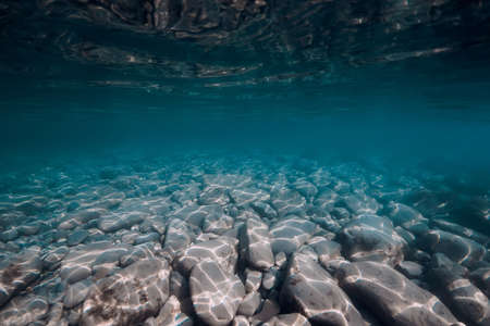 Underwater view with stones bottom in turquoise water. Sea backgroundの写真素材