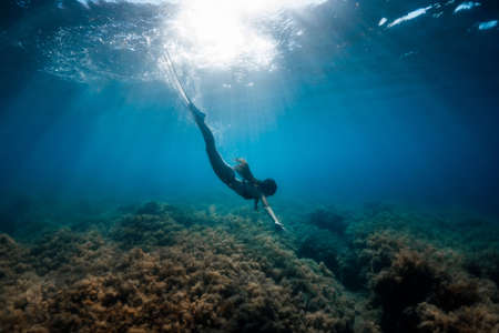 Freediver woman with white fins relax in sea.