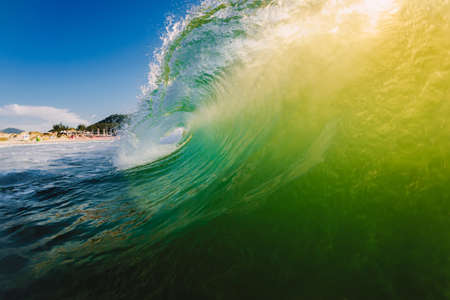 Perfect surfing wave in the ocean. Glassy barrels waves with morning lightの写真素材