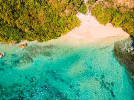 Aerial view of sandy beach with turquoise sea water and local tradition boats in Bali, Thomas beach