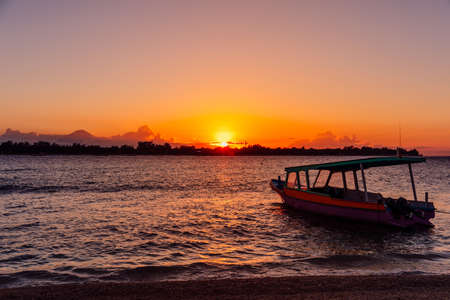 Sunset or sunrise at tropical beach with boat and ocean in Gili Meno islandの写真素材