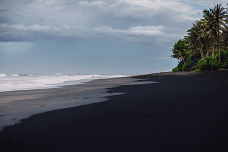 Tropical ocean with waves and surfer in Bali. Aerial view at Balangan beach.の写真素材