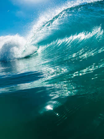 Barrel wave in tropical ocean. Breaking blue wave with sunlightの写真素材