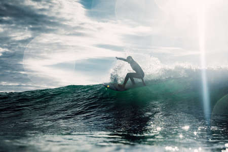 February 15, 2022. Brazil, Florianopolis. Young woman in wetsuit during surfing with morning light....