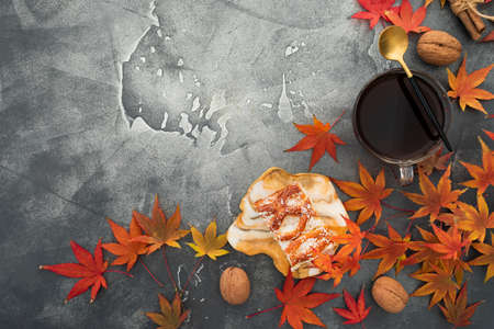 Autumn frame composition. Fall maple leaves with walnuts, cup of coffee and resin art plate on stone background. Autumnal thanksgiving day concept. Flat lay, top viewの写真素材