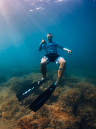 August 07, 2021. Varna, Bulgaria. Men freediver dive with fins in sea. Freediving underwater in transparent seaの写真素材
