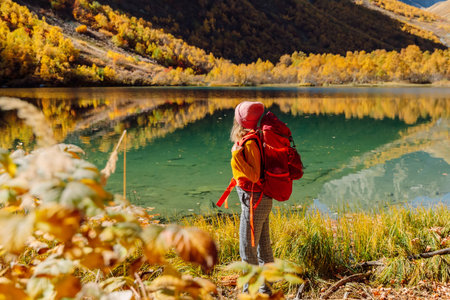 Hiker woman with backpack in the mountains. Mountain with glacier and touristの写真素材