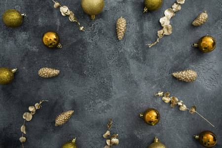 Holidays frame with golden Christmas decoration on dark background. Winter celebrations. Flat lay, top viewの写真素材