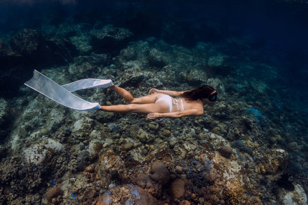 Woman freediver swim near big coral. Freediving in deep oceanの写真素材