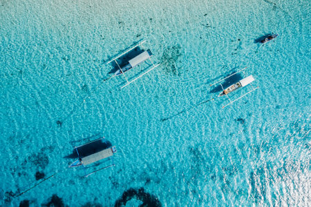 Boats are at anchor in blue ocean on paradise island. Aerial view.