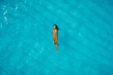 Beautiful woman swimming in blue ocean. Aerial view, top view.の写真素材