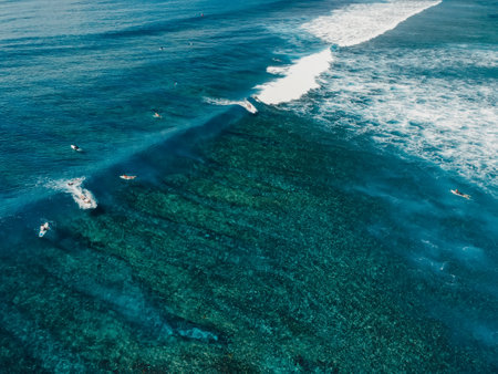 Aerial view with surfing on glassy wave. Perfect waves with surfers in clear oceanの写真素材